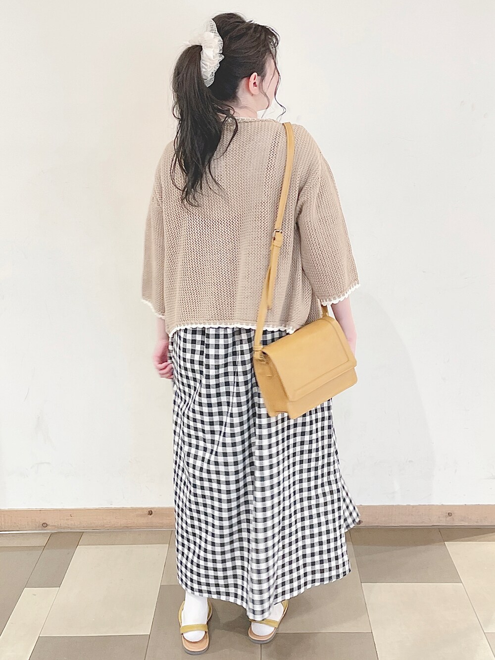 イエロー系のショルダーバッグ、イエロー系のサンダル、ホワイト系のTシャツ/カットソーを着用したレディースの春コーディネートの5枚目の写真