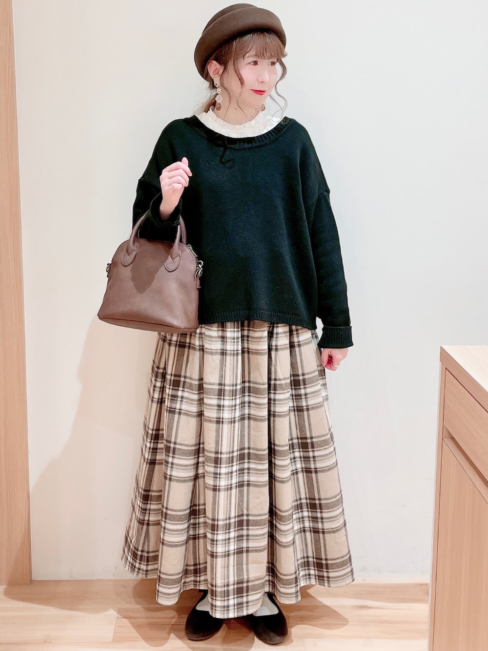 ホワイト系のシャツ/ブラウス、ブラック系のカーディガン/ボレロ、ブラウン系のショルダーバッグを着用したレディースの冬コーディネートの3枚目の写真