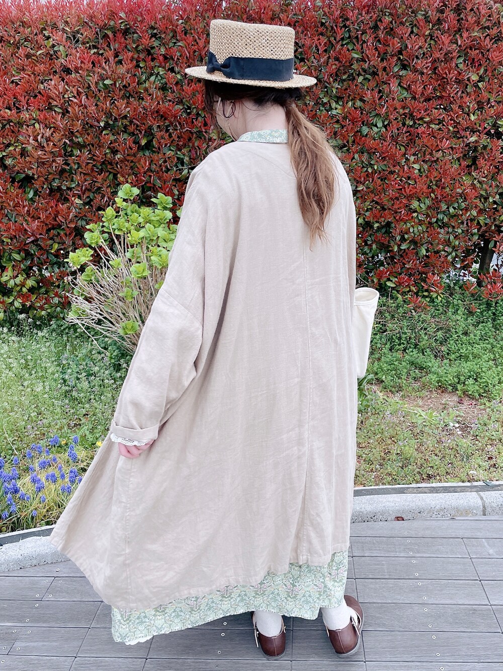 グリーン系のワンピース、ベージュ系のその他アウター、ブラウン系のサンダルを着用したレディースの春コーディネートの4枚目の写真