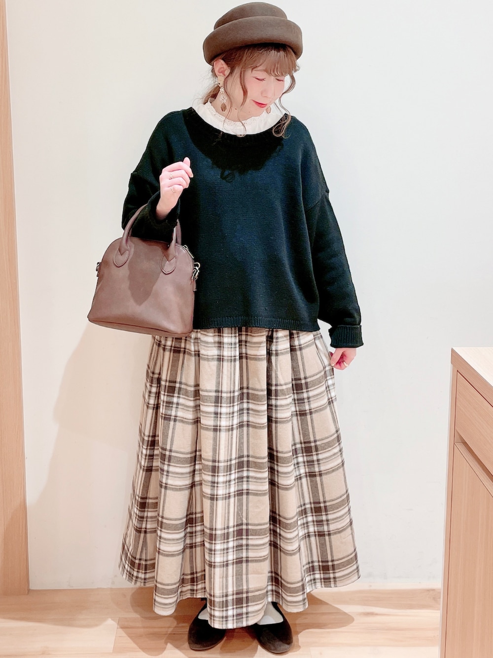 ホワイト系のシャツ/ブラウス、ブラック系のカーディガン/ボレロ、ブラウン系のショルダーバッグを着用したレディースの冬コーディネートの2枚目の写真