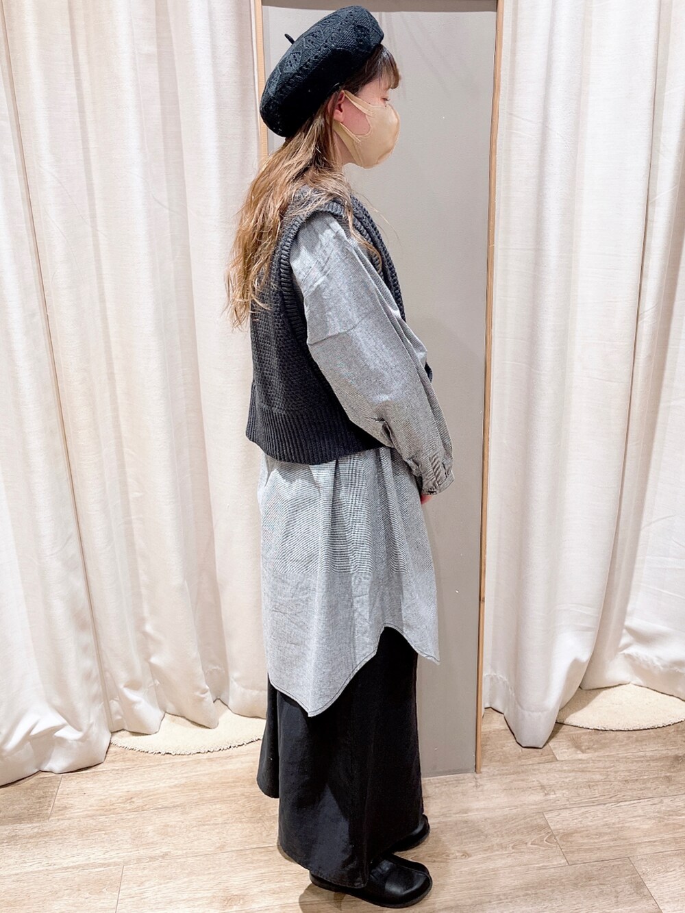 ブラック系のシャツ/ブラウス、グレー系のニット/セーター、ブラック系のスカートを着用したレディースの冬コーディネートの3枚目の写真