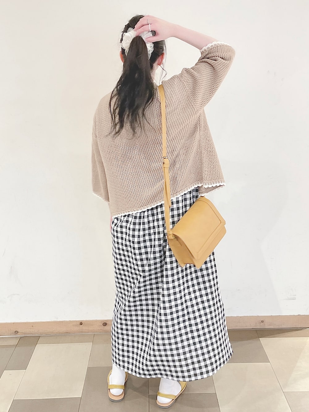 イエロー系のショルダーバッグ、イエロー系のサンダル、ホワイト系のTシャツ/カットソーを着用したレディースの春コーディネートの4枚目の写真