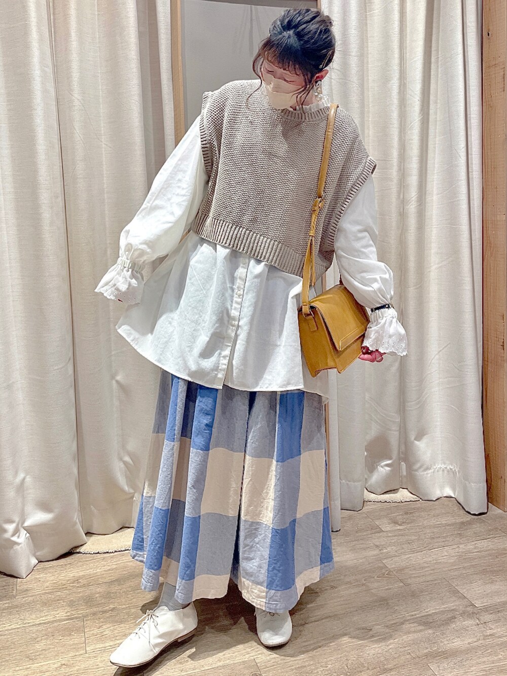 ベージュ系のベスト、ホワイト系のシャツ/ブラウス、ホワイト系のローファーを着用したレディースの冬コーディネートの2枚目の写真