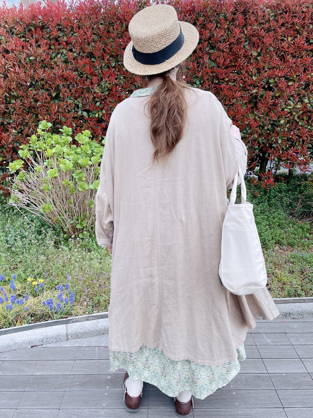 グリーン系のワンピース、ベージュ系のその他アウター、ブラウン系のサンダルを着用したレディースの春コーディネートの5枚目の写真