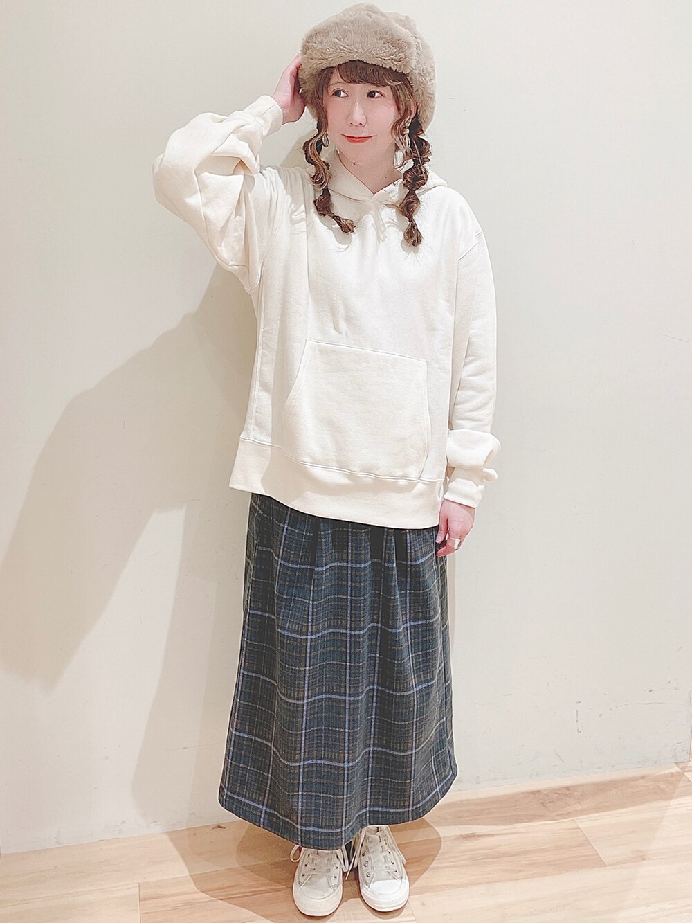 ホワイト系のパーカー、グリーン系のスカート、ホワイト系のスニーカーを着用したレディースの秋コーディネートの2枚目の写真