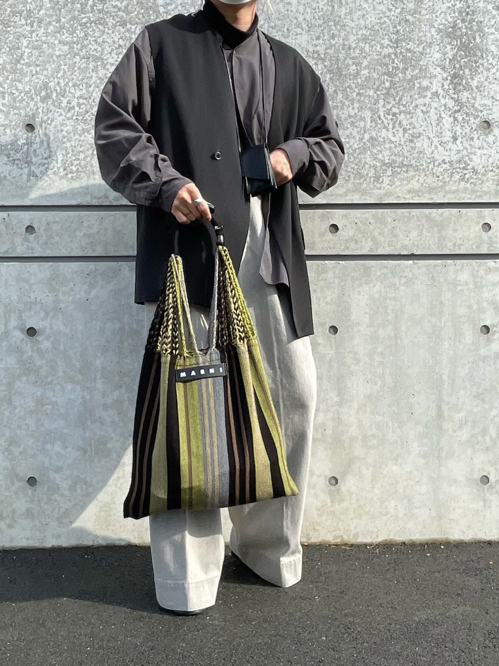 グレー系のデニムパンツ、ブラック系のニット/セーター、ブラック系のベストを着用したメンズの冬コーディネートの3枚目の写真