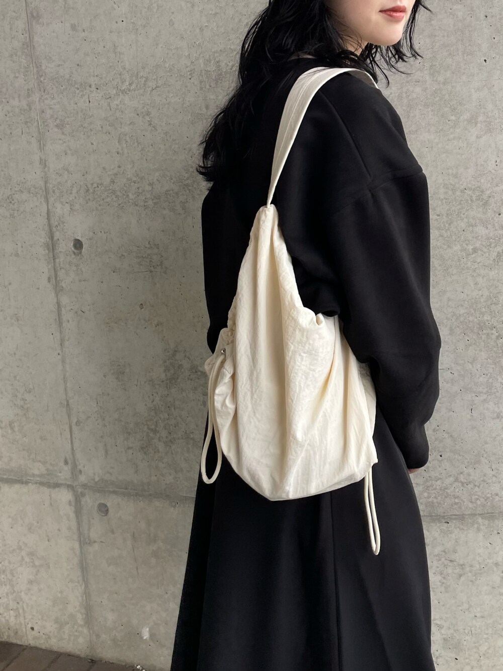 ブラック系のワンピース、ホワイト系のショルダーバッグを着用したレディースの秋コーディネートの3枚目の写真