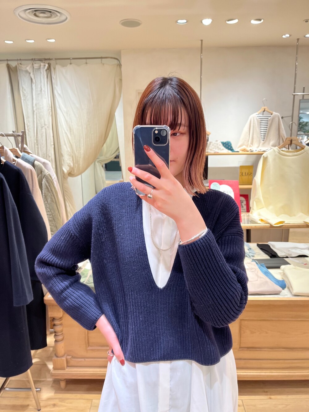 ブルー系のニット/セーター、ホワイト系のワンピース、ブルー系のデニムパンツを着用したレディースの冬コーディネートの2枚目の写真