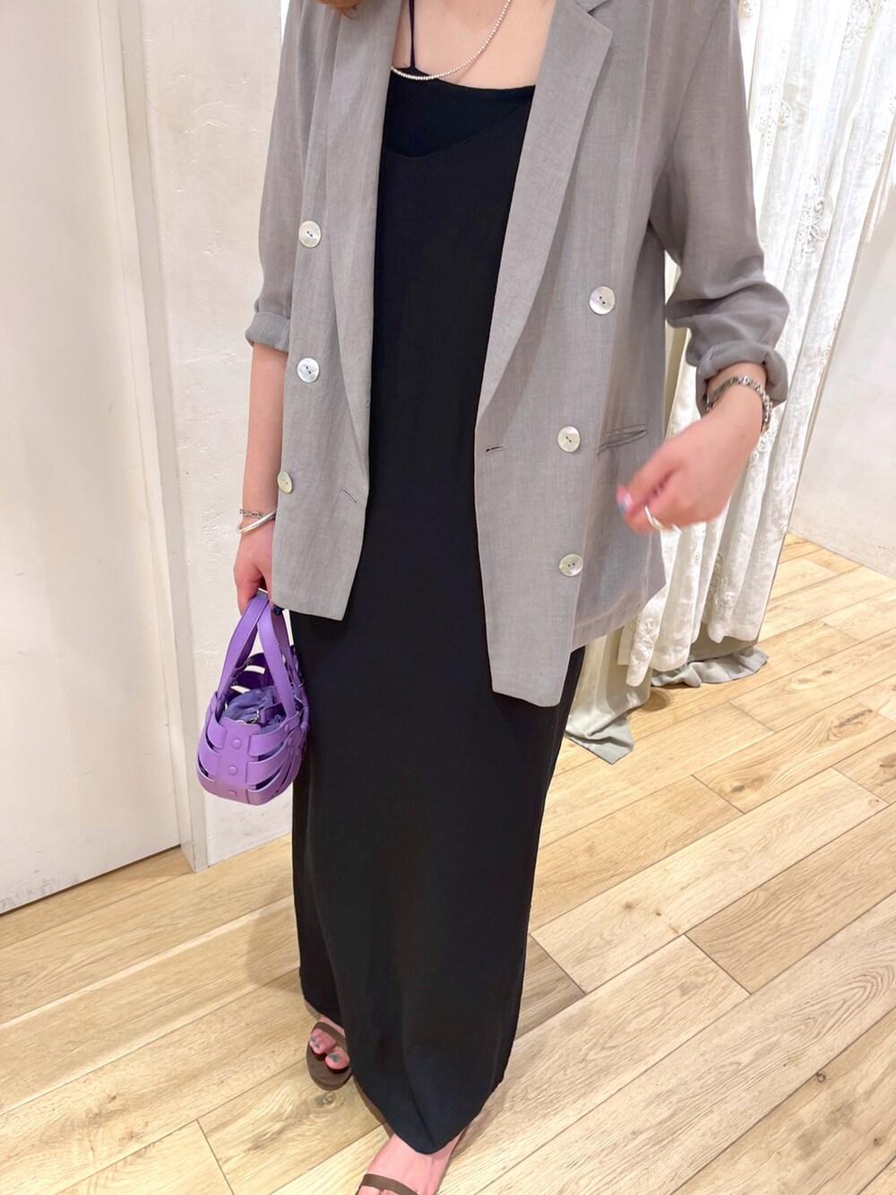 ブラック系のワンピース、パープル系のトートバッグ、グレー系のテーラードジャケットを着用したレディースの夏コーディネートの2枚目の写真