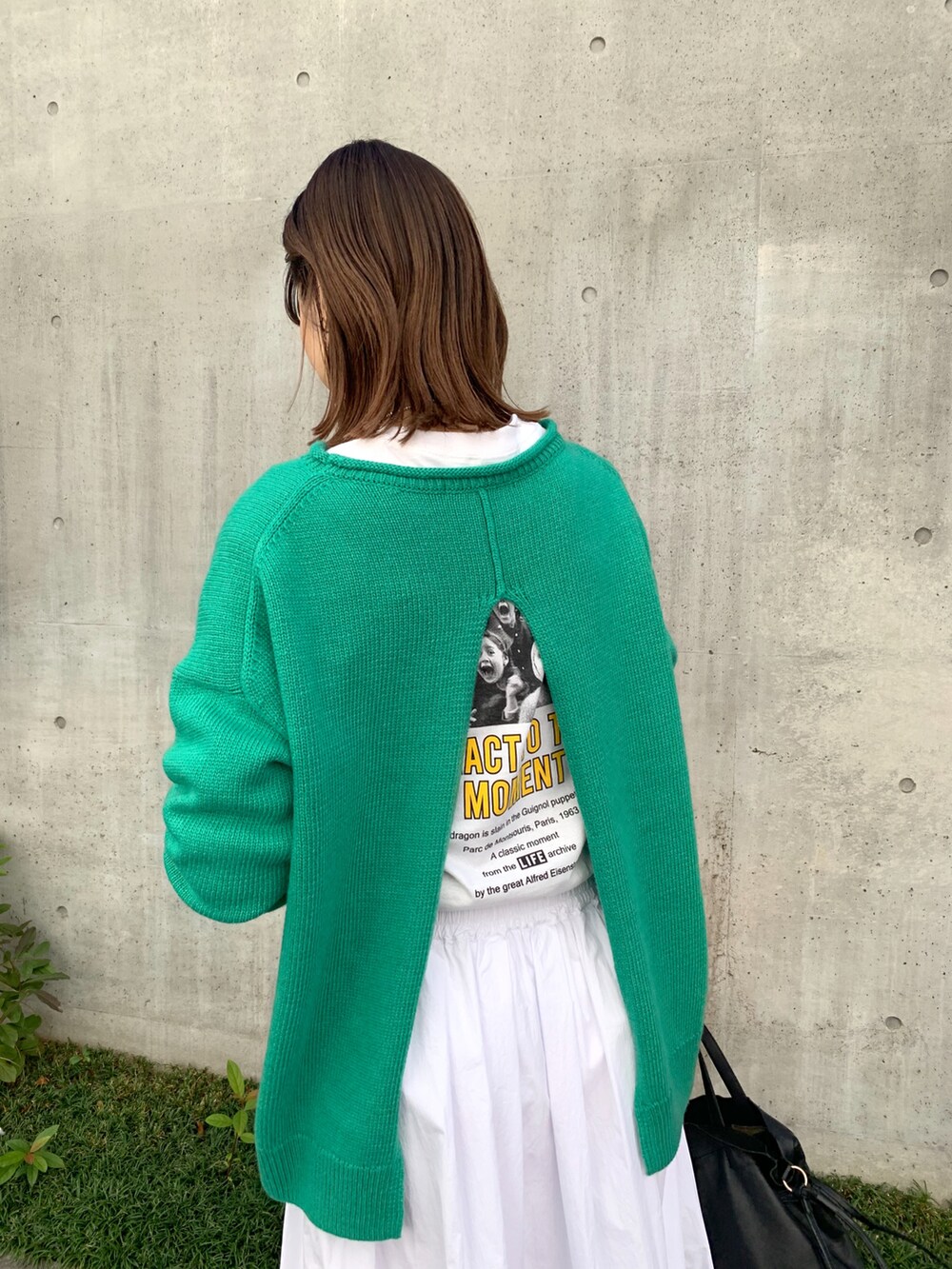 グリーン系のニット/セーター、ホワイト系のスカート、ブラウン系のローファーを着用したレディースの秋コーディネートの3枚目の写真