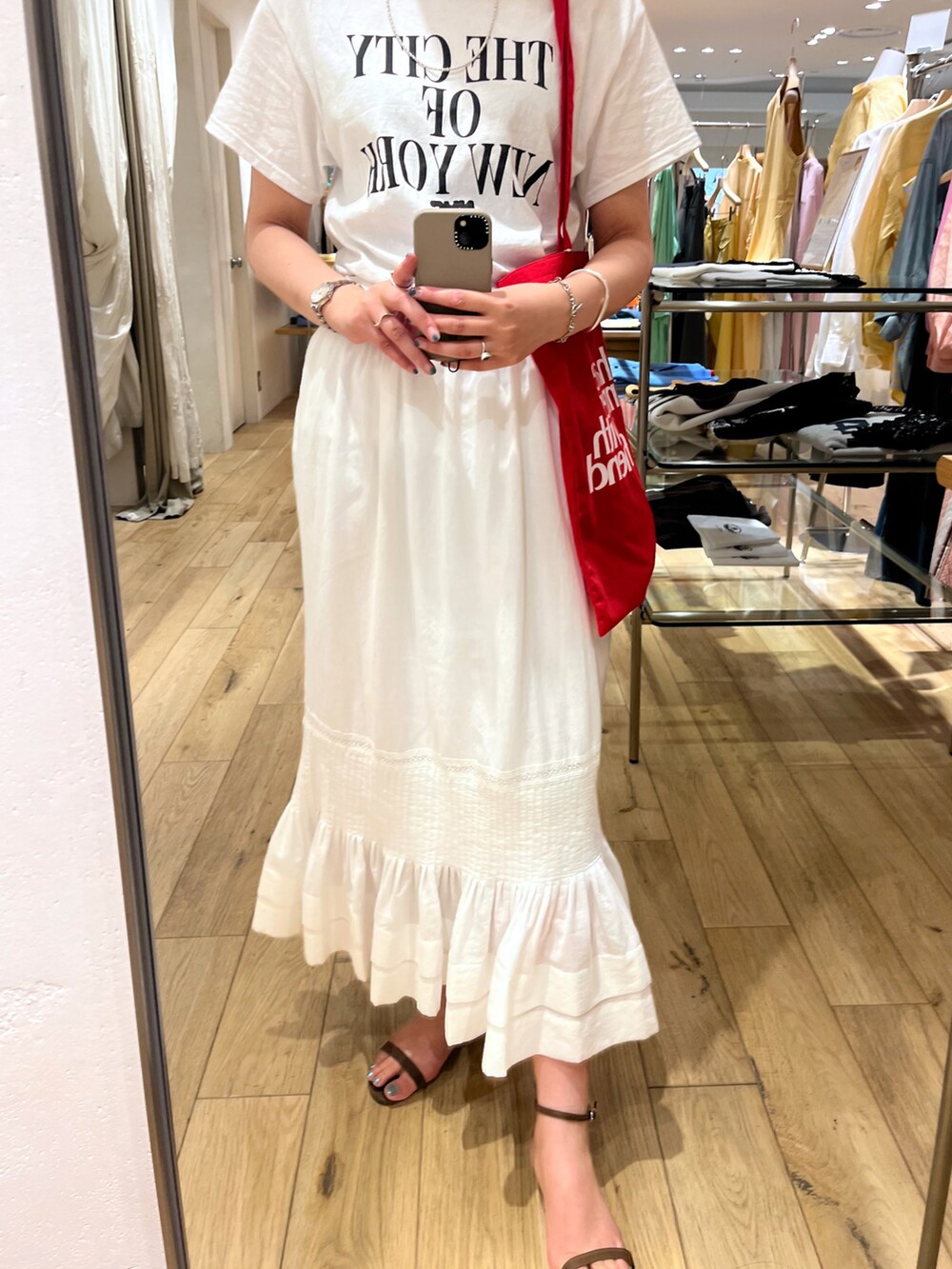 ホワイト系のTシャツ/カットソー、ホワイト系のトートバッグ、ホワイト系のスカートを着用したレディースの夏コーディネートの4枚目の写真