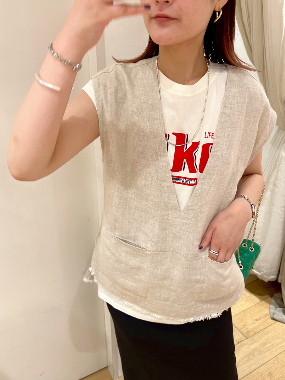 ベージュ系のベスト、ブラック系のワンピース、ブラック系のサンダルを着用したレディースの夏コーディネートの2枚目の写真