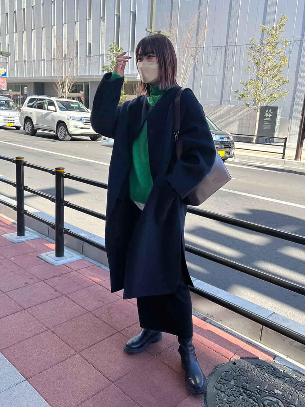 ブルー系のその他アウター、ブラック系のスカート、グリーン系のニット/セーターを着用したレディースの冬コーディネートの2枚目の写真