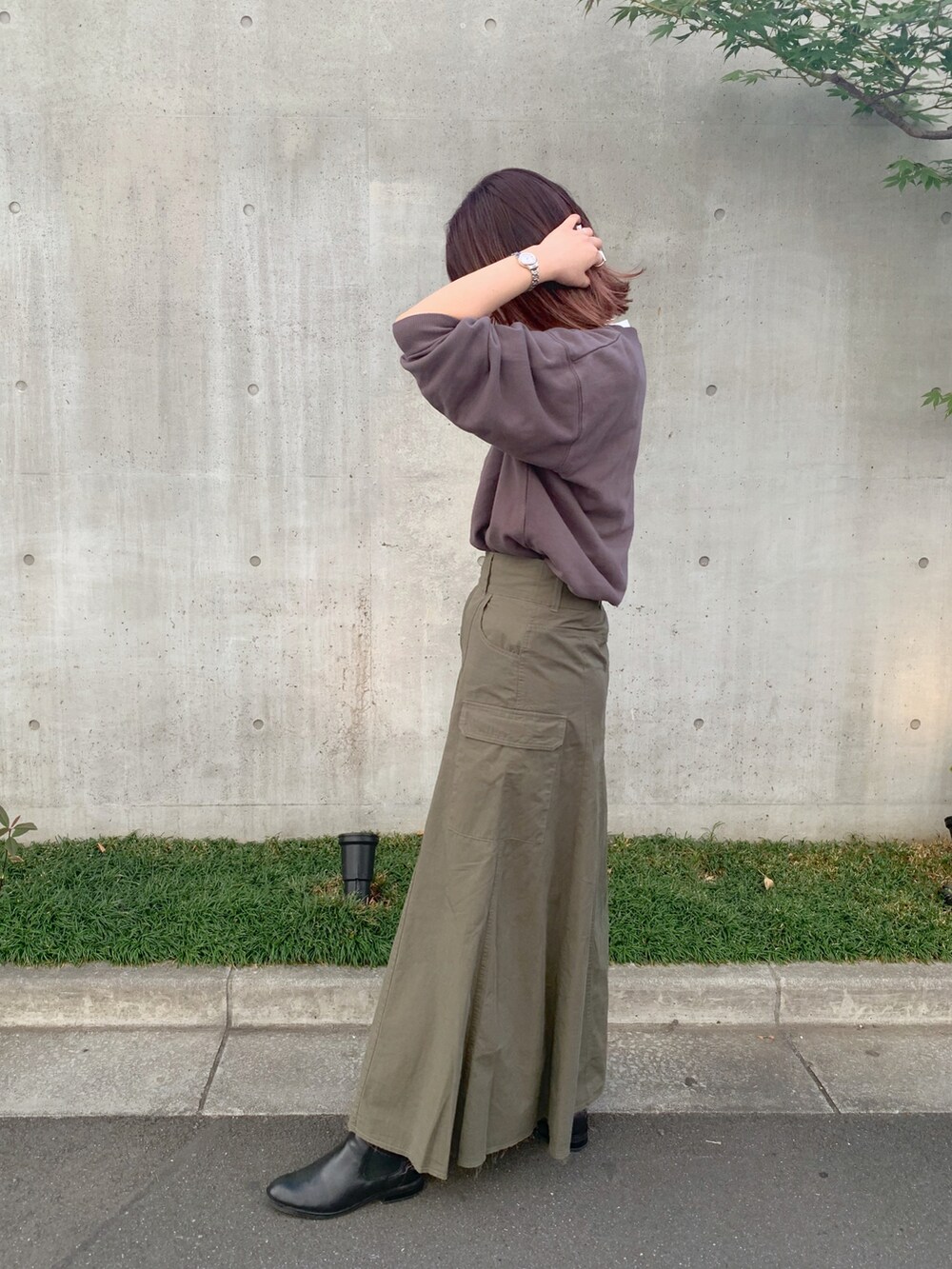 グレー系のTシャツ/カットソー、グリーン系のスカート、ブラック系のトートバッグを着用したレディースの秋コーディネートの2枚目の写真