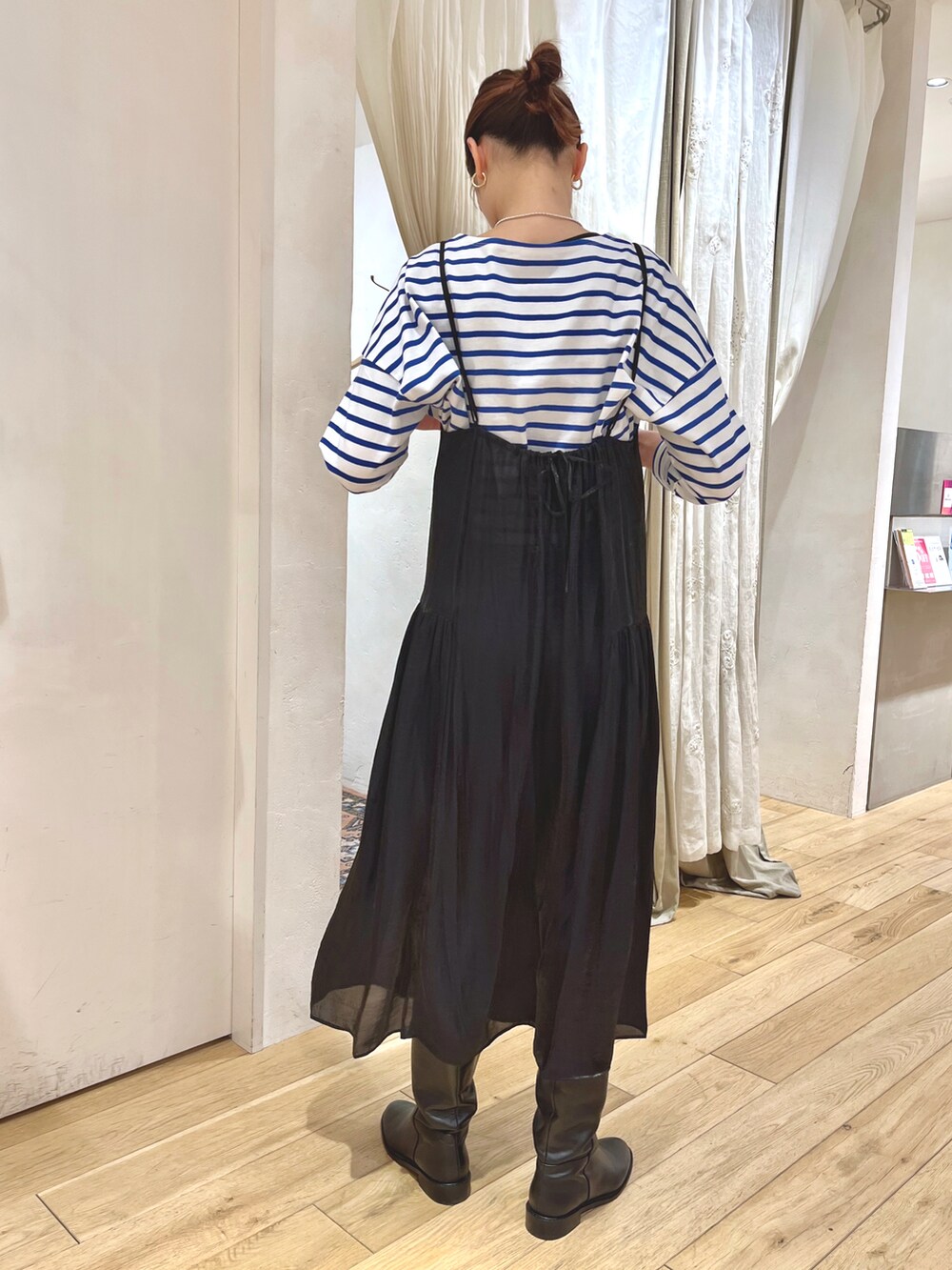 ブルー系のTシャツ/カットソー、ブラック系のワンピース、ブラック系のブーツを着用したレディースの冬コーディネートの2枚目の写真
