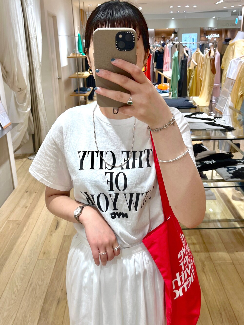 ホワイト系のTシャツ/カットソー、ホワイト系のトートバッグ、ホワイト系のスカートを着用したレディースの夏コーディネートの3枚目の写真