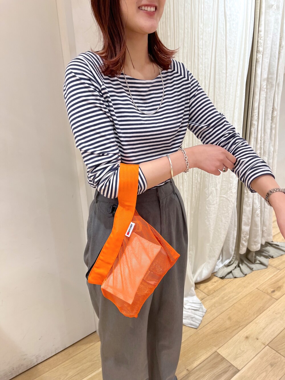ブラック系のTシャツ/カットソー、オレンジ系のハンドバッグ、グレー系のその他パンツを着用したレディースの夏コーディネートの2枚目の写真