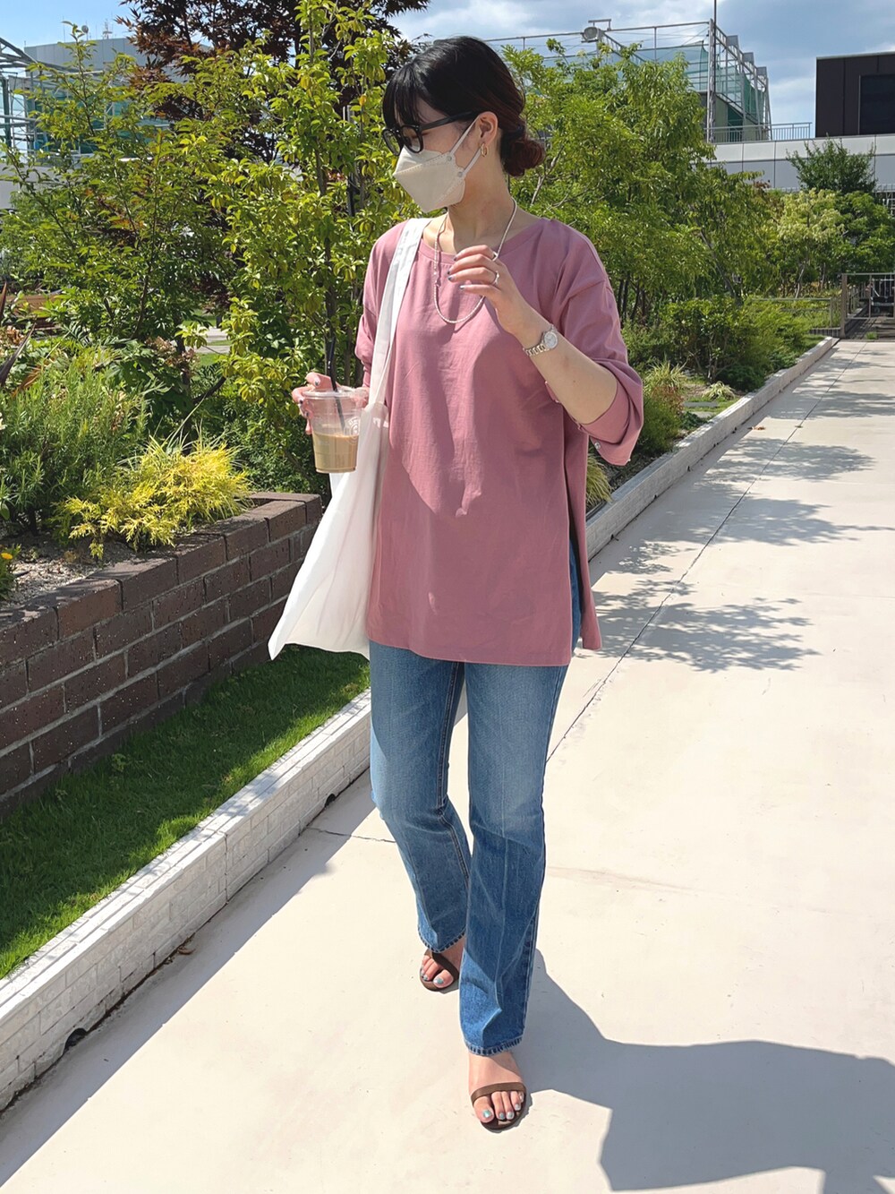 ホワイト系のトートバッグ、ブルー系のデニムパンツ、ピンク系のTシャツ/カットソーを着用したレディースの夏コーディネートの2枚目の写真