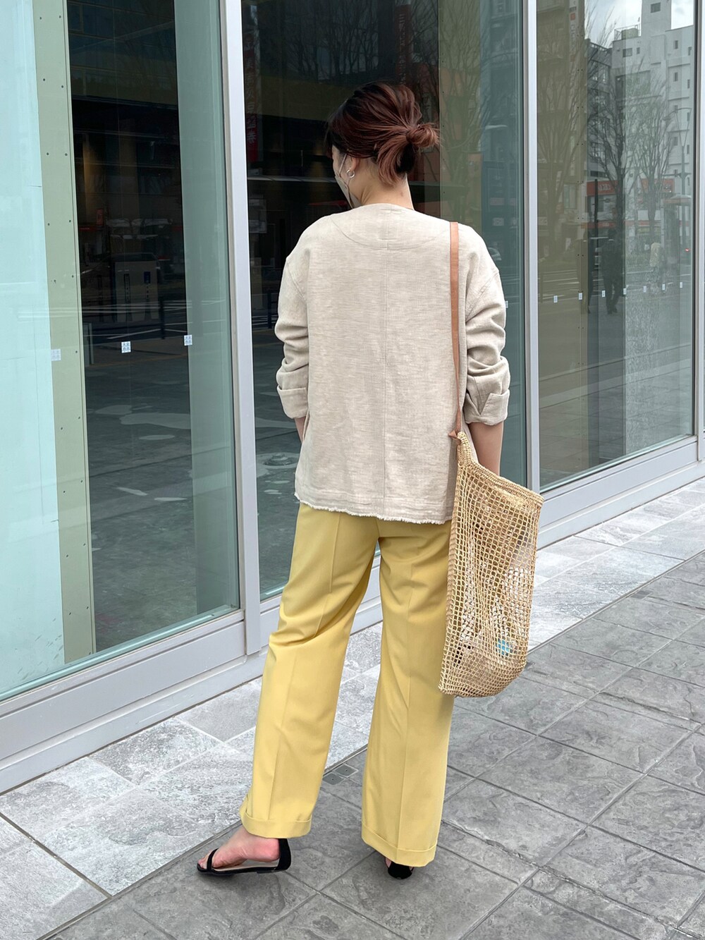 イエロー系のその他パンツ、ベージュ系のその他アウター、ホワイト系のTシャツ/カットソーを着用したレディースの春コーディネートの2枚目の写真