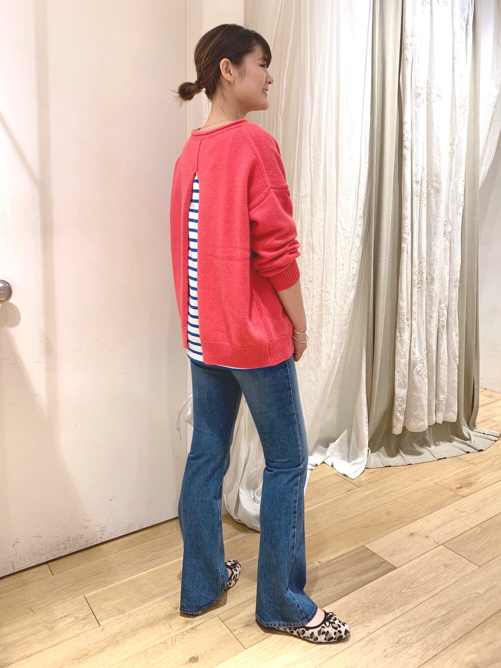 ピンク系のニット/セーター、シルバー系のトートバッグ、ブルー系のデニムパンツを着用したレディースの秋コーディネートの2枚目の写真