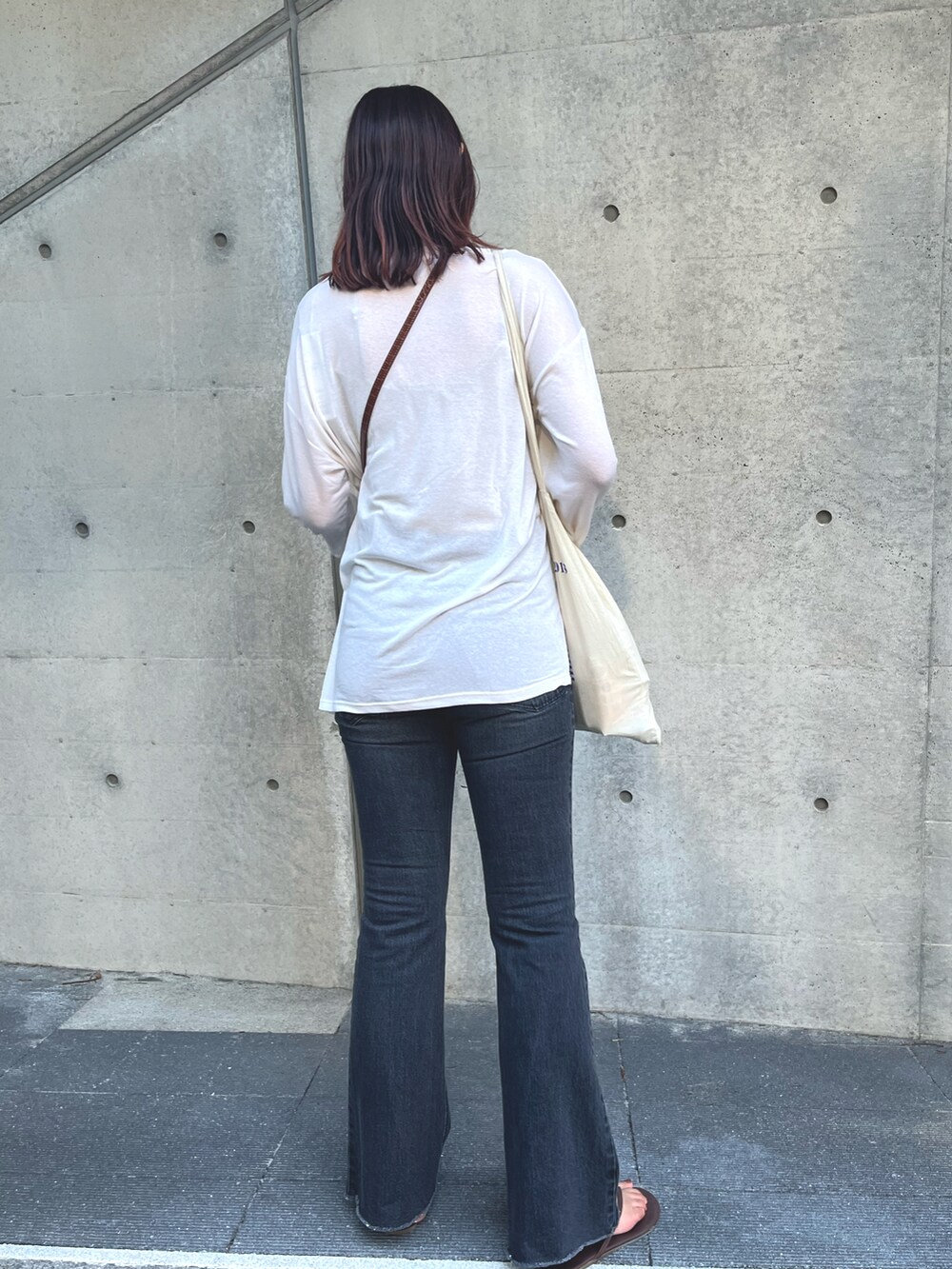 ホワイト系のTシャツ/カットソー、ブラウン系のショルダーバッグ、ブラック系のデニムパンツを着用したレディースの夏コーディネートの2枚目の写真
