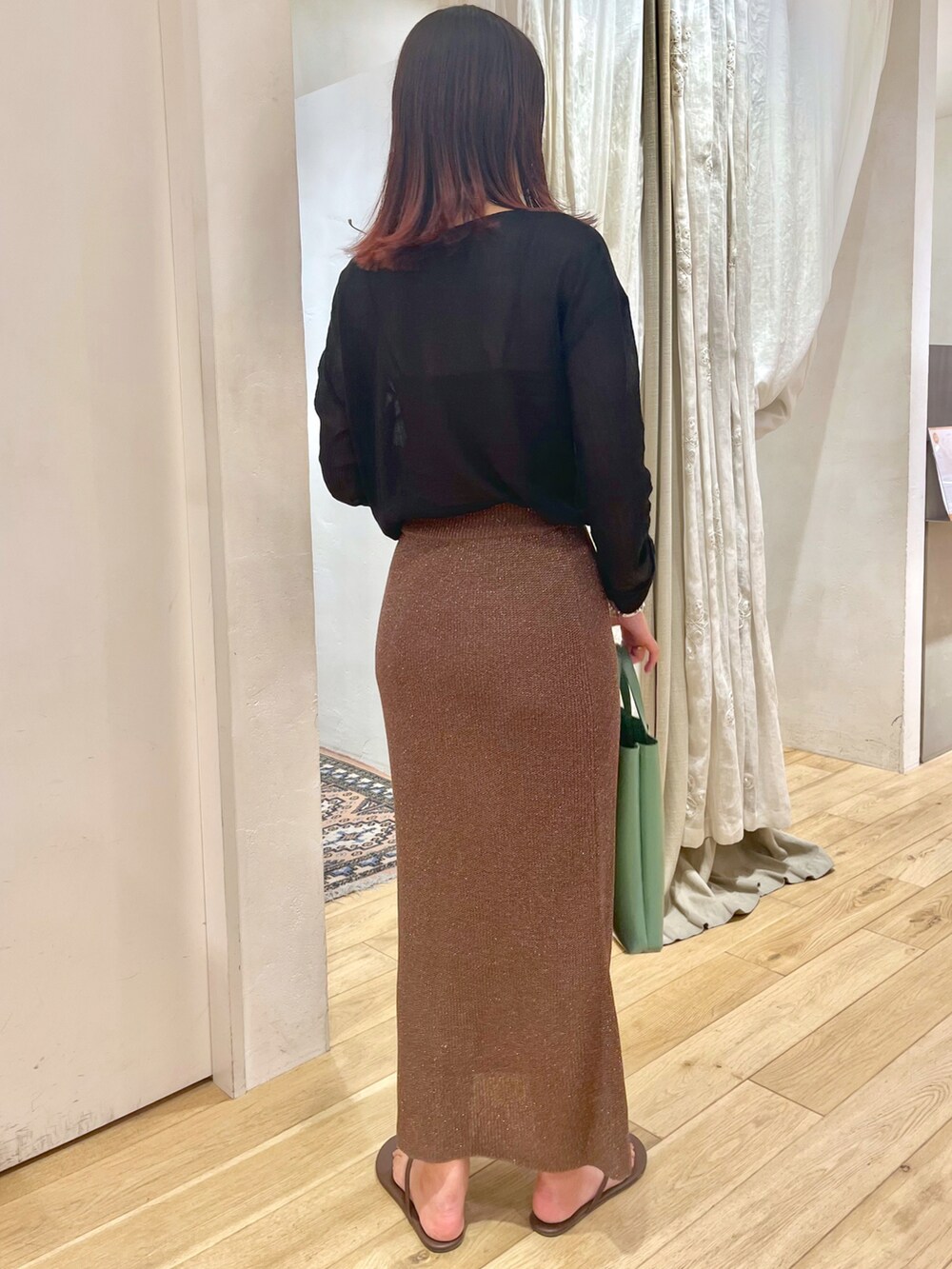 ブラウン系のスカート、ブラック系のシャツ/ブラウス、グリーン系のショルダーバッグを着用したレディースの夏コーディネートの2枚目の写真