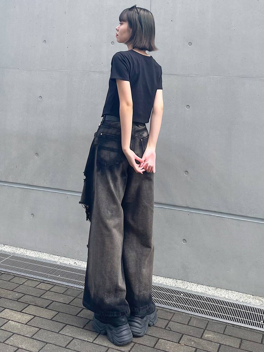 ブラック系のスニーカー、ブラック系のデニムパンツ、ブラック系のTシャツ/カットソーを着用したレディースの夏コーディネートの5枚目の写真