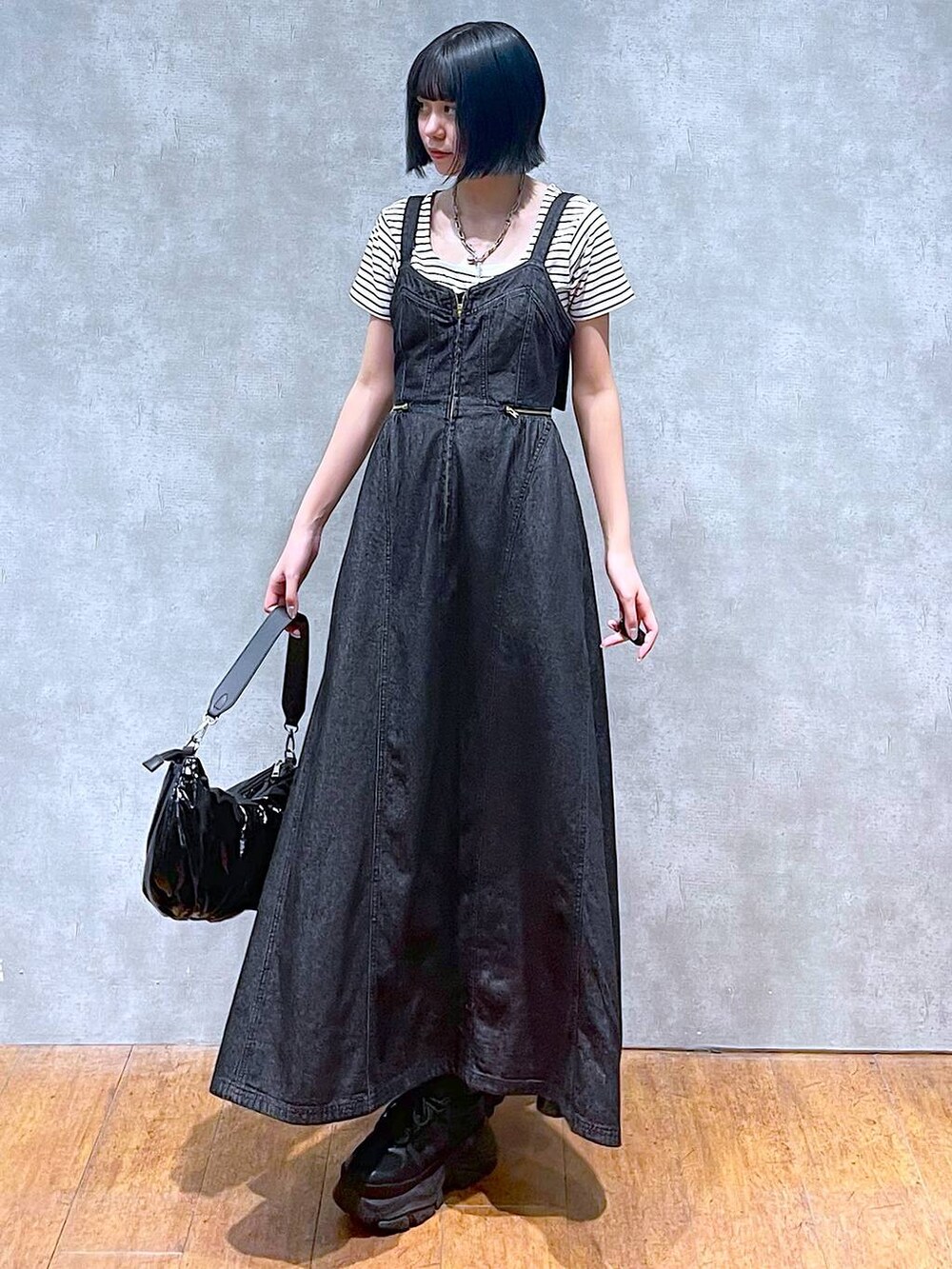 ブラック系のスニーカー、ブラック系のワンピース、ホワイト系のTシャツ/カットソーを着用したレディースの夏コーディネートの6枚目の写真