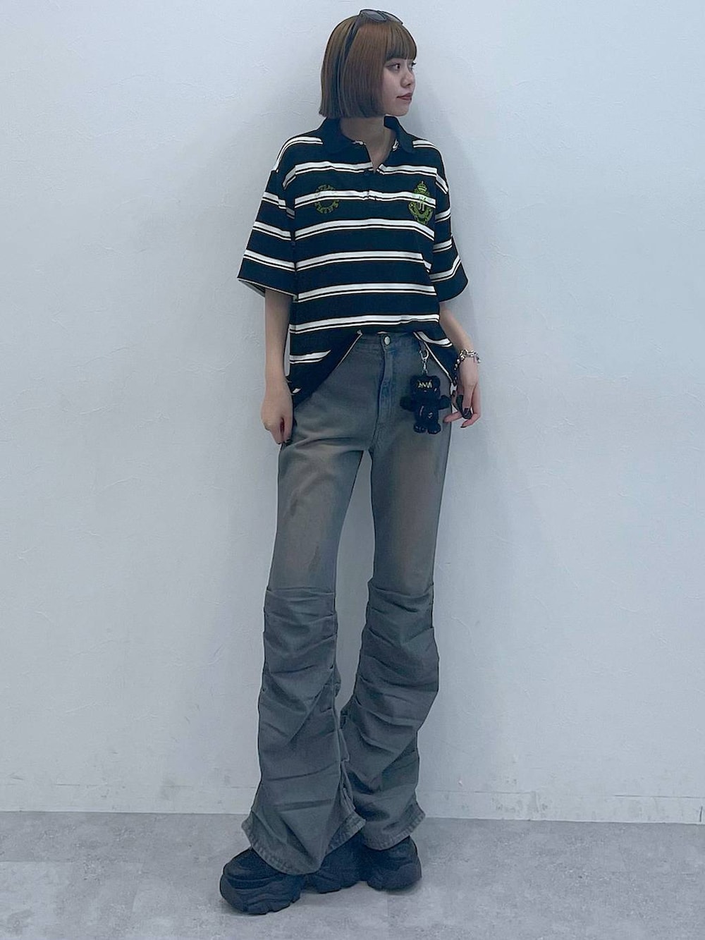 ブラック系のスニーカー、ブラック系のTシャツ/カットソー、ブルー系のデニムパンツを着用したレディースの夏コーディネートの2枚目の写真