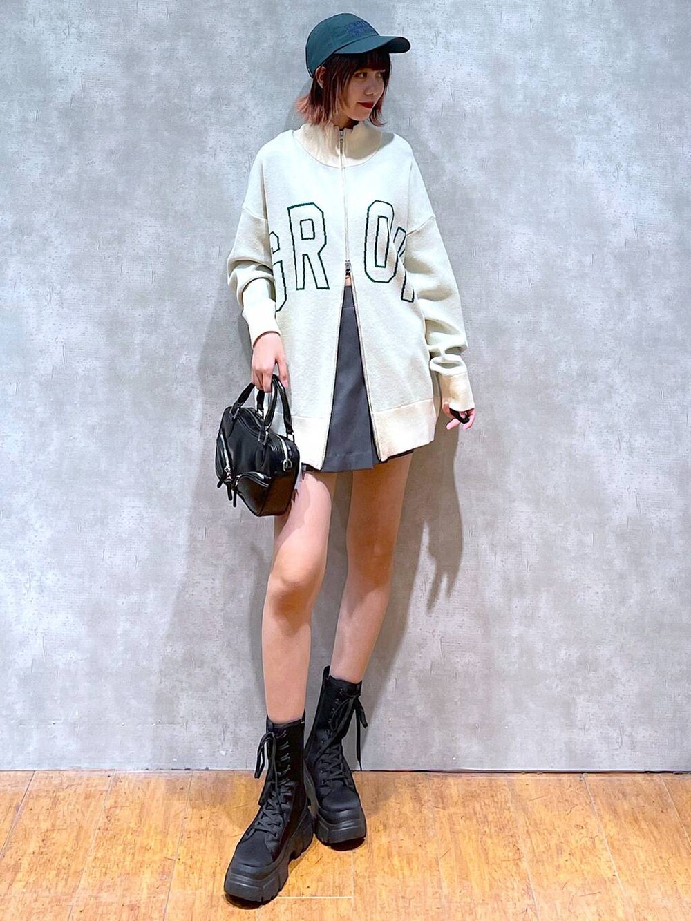 ベージュ系のニット/セーター、グレー系のその他パンツ、ブラック系のブーツを着用したレディースの春コーディネートの3枚目の写真