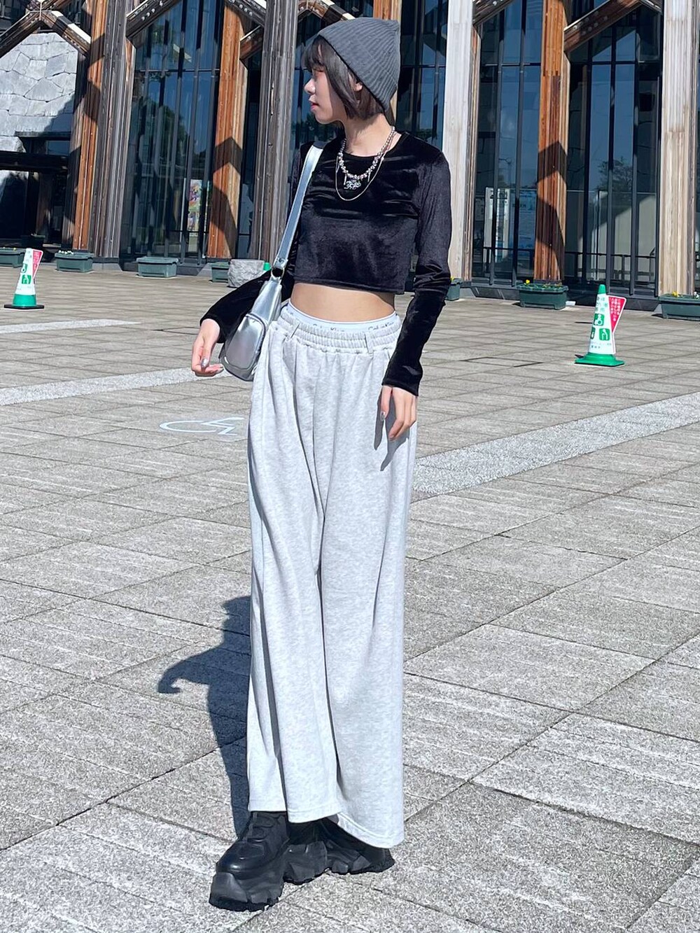 ブラック系のスニーカー、シルバー系のショルダーバッグ、ブラック系のTシャツ/カットソーを着用したレディースの秋コーディネートの7枚目の写真