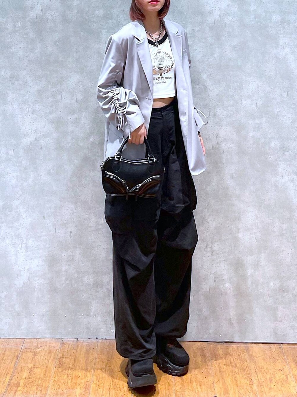 ベージュ系のテーラードジャケット、ホワイト系のTシャツ/カットソー、ブラック系のカーゴパンツを着用したレディースの春コーディネートの5枚目の写真