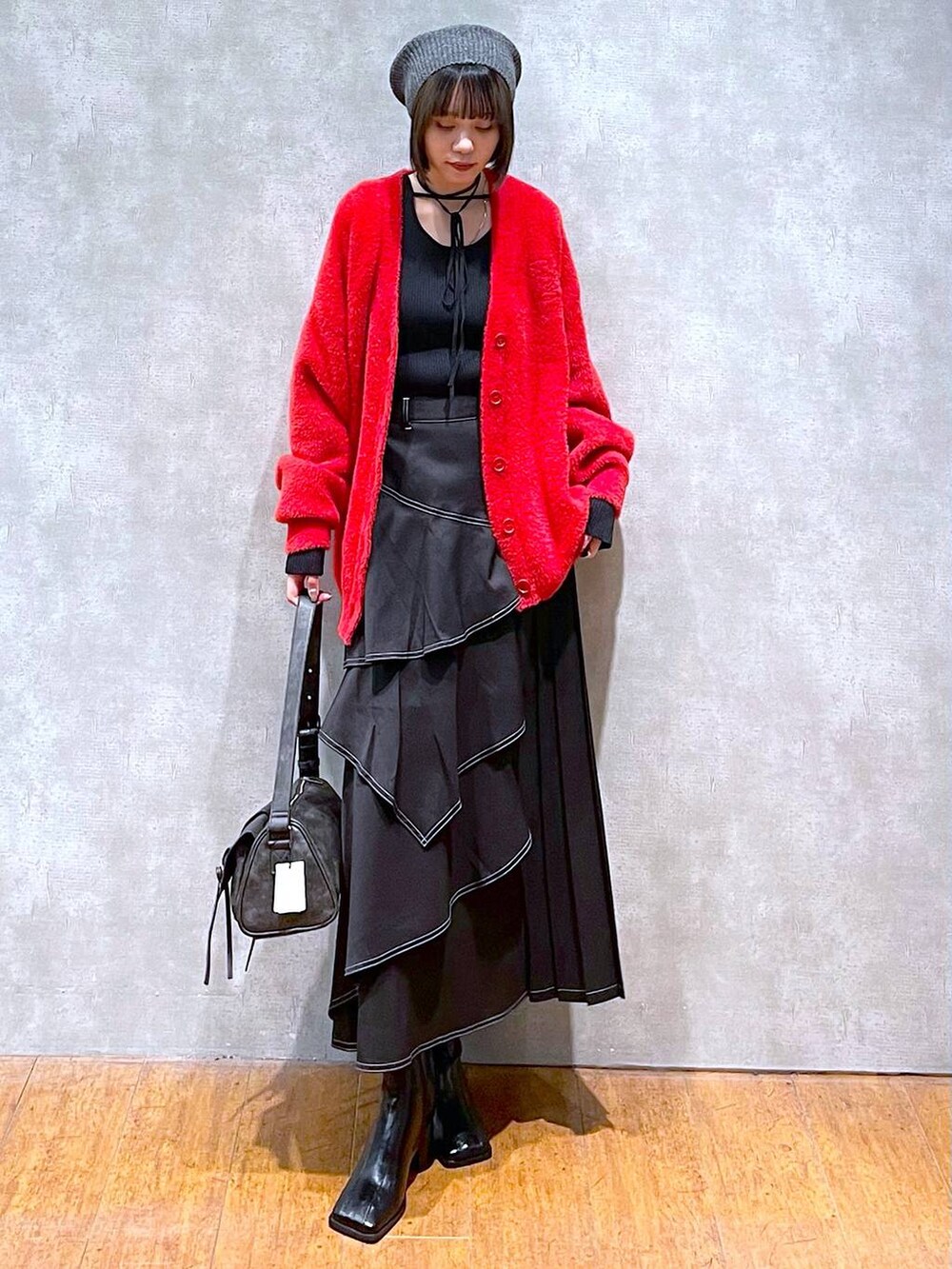 ブラック系のショルダーバッグ、ブラック系のブーツ、ブラック系のスカートを着用したレディースの秋コーディネートの9枚目の写真