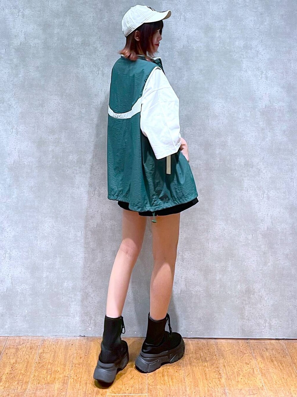 グリーン系のベスト、ホワイト系のTシャツ/カットソー、ブラック系のその他パンツを着用したレディースの春コーディネートの5枚目の写真