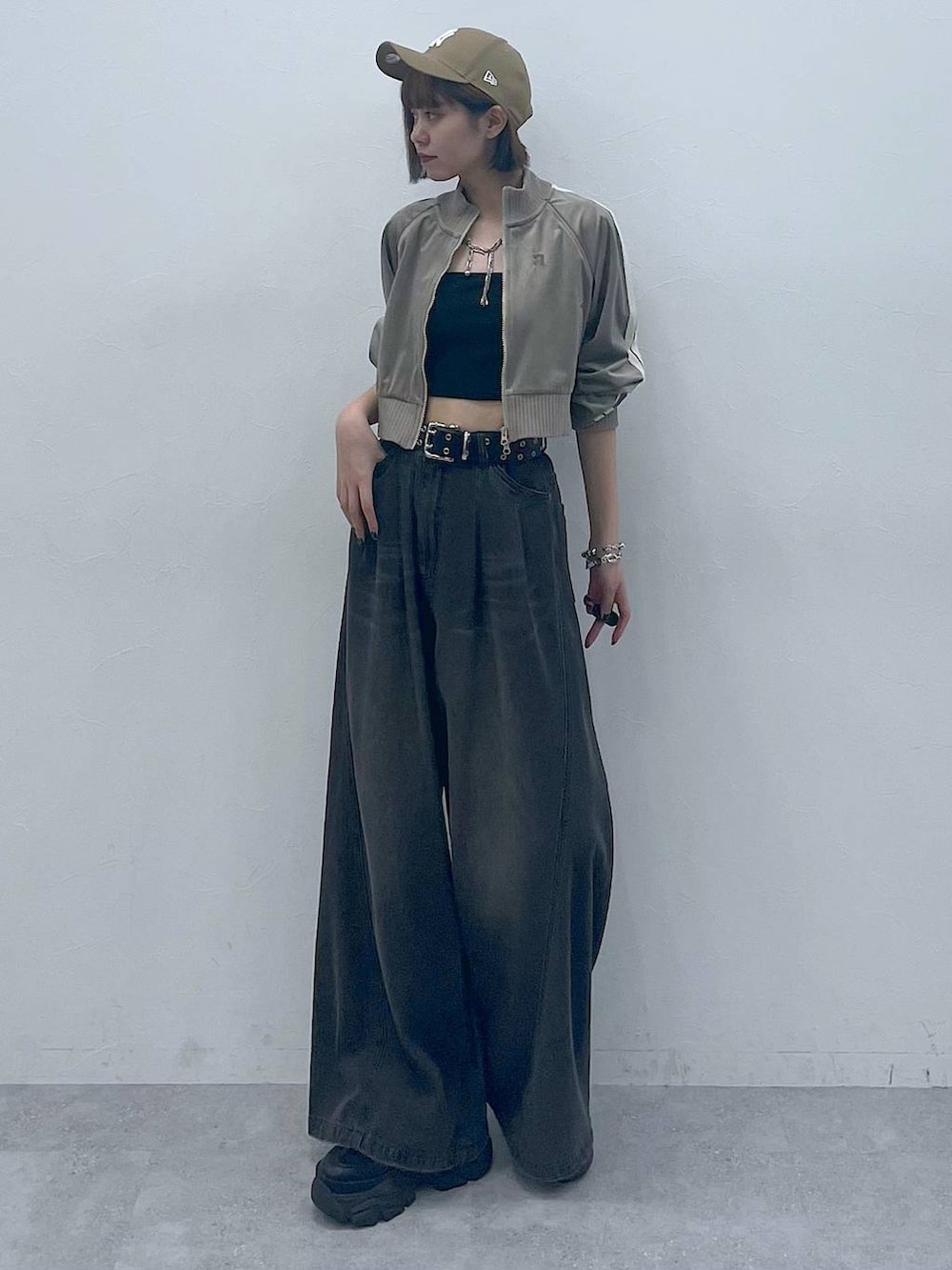 ブラック系のスニーカー、ブラック系のキャミソール、ブラック系のデニムパンツを着用したレディースの秋コーディネートの2枚目の写真