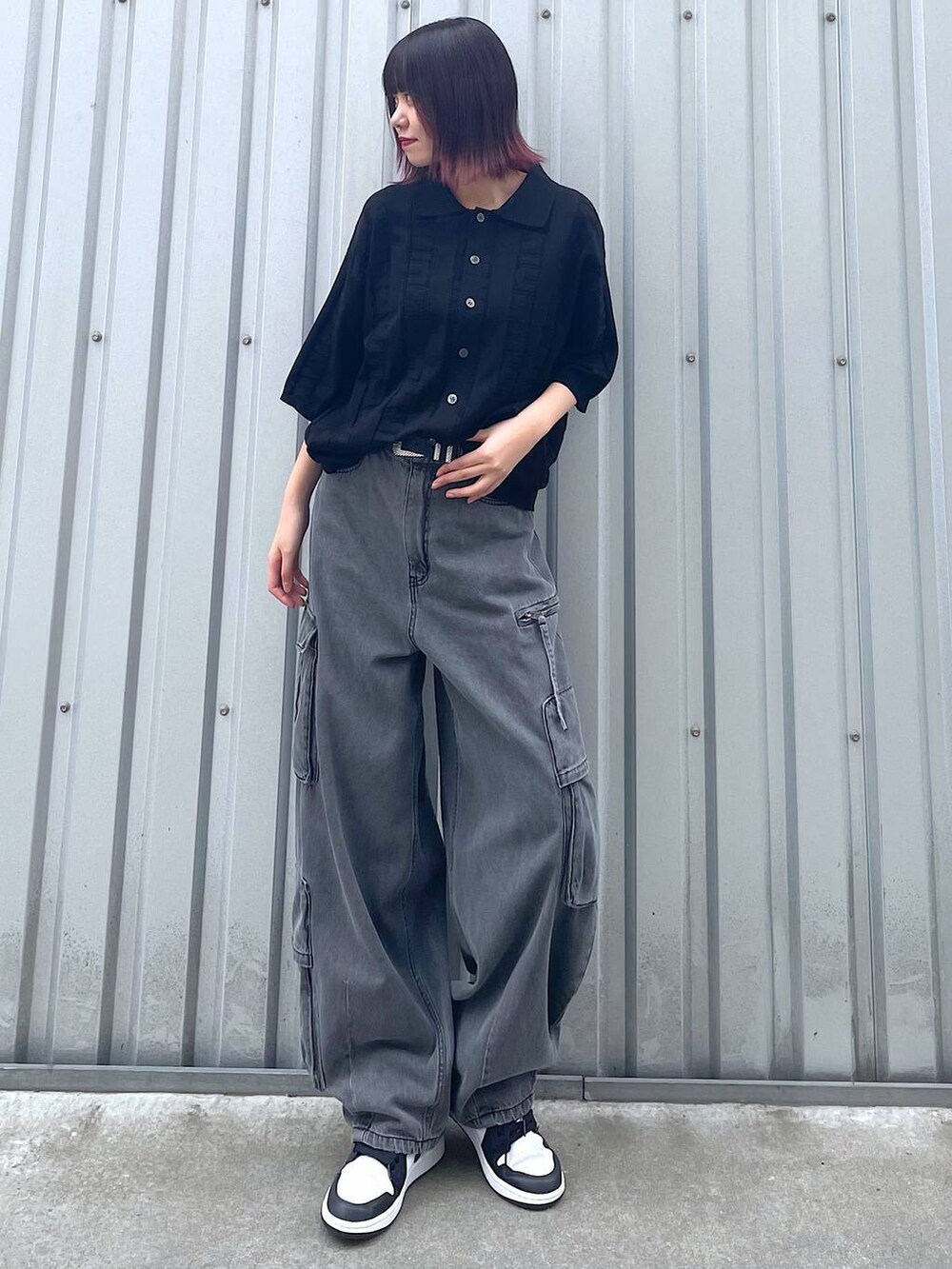 ブラック系のニット/セーター、ブラック系のデニムパンツ、ブラック系のベルトを着用したレディースの春コーディネートの3枚目の写真