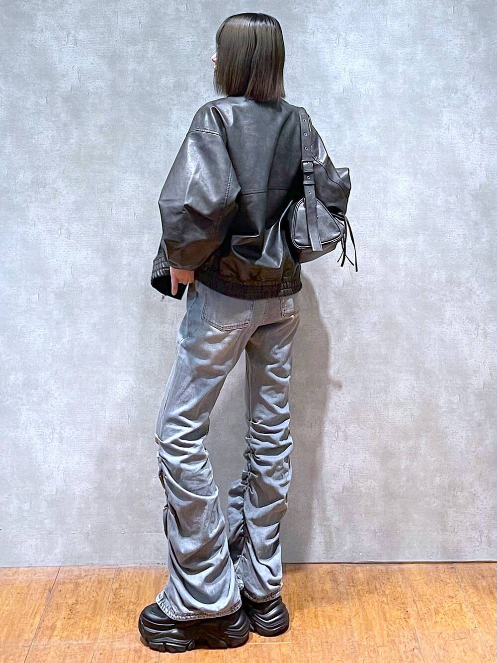 ブラック系のスニーカー、ブラック系のショルダーバッグ、ブルー系のデニムパンツを着用したレディースの秋コーディネートの9枚目の写真