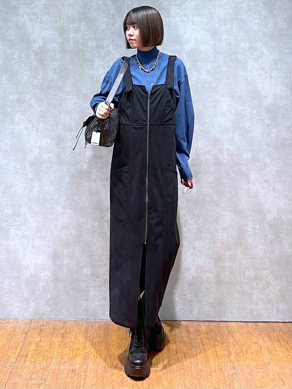 ブラック系のショルダーバッグ、ブラック系のブーツ、ブルー系のニット/セーターを着用したレディースの秋コーディネートの8枚目の写真