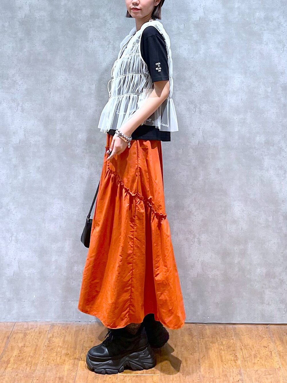 ブラック系のスニーカー、ブラック系のハンドバッグ、ブラック系のTシャツ/カットソーを着用したレディースの夏コーディネートの5枚目の写真