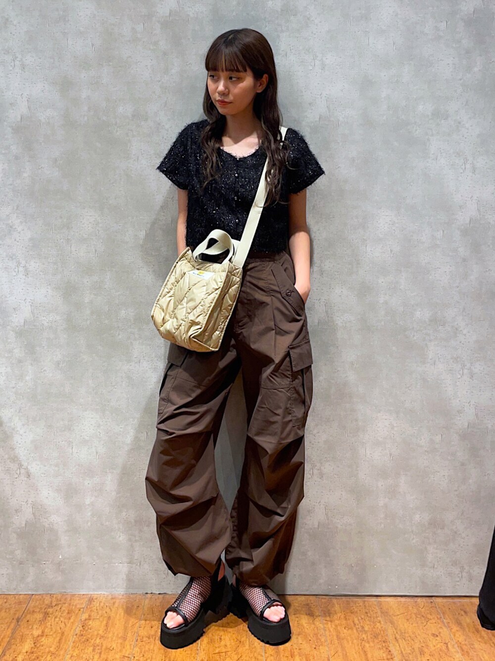 ブラック系のTシャツ/カットソー、ベージュ系のショルダーバッグ、ブラウン系のスラックスを着用したレディースの夏コーディネートの3枚目の写真