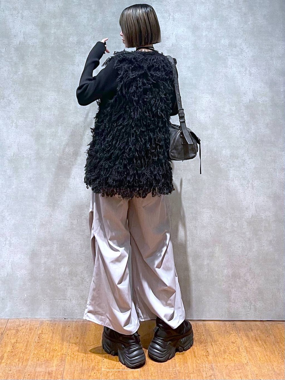 ブラック系のスニーカー、ブラック系のショルダーバッグ、グレー系のその他パンツを着用したレディースの秋コーディネートの2枚目の写真