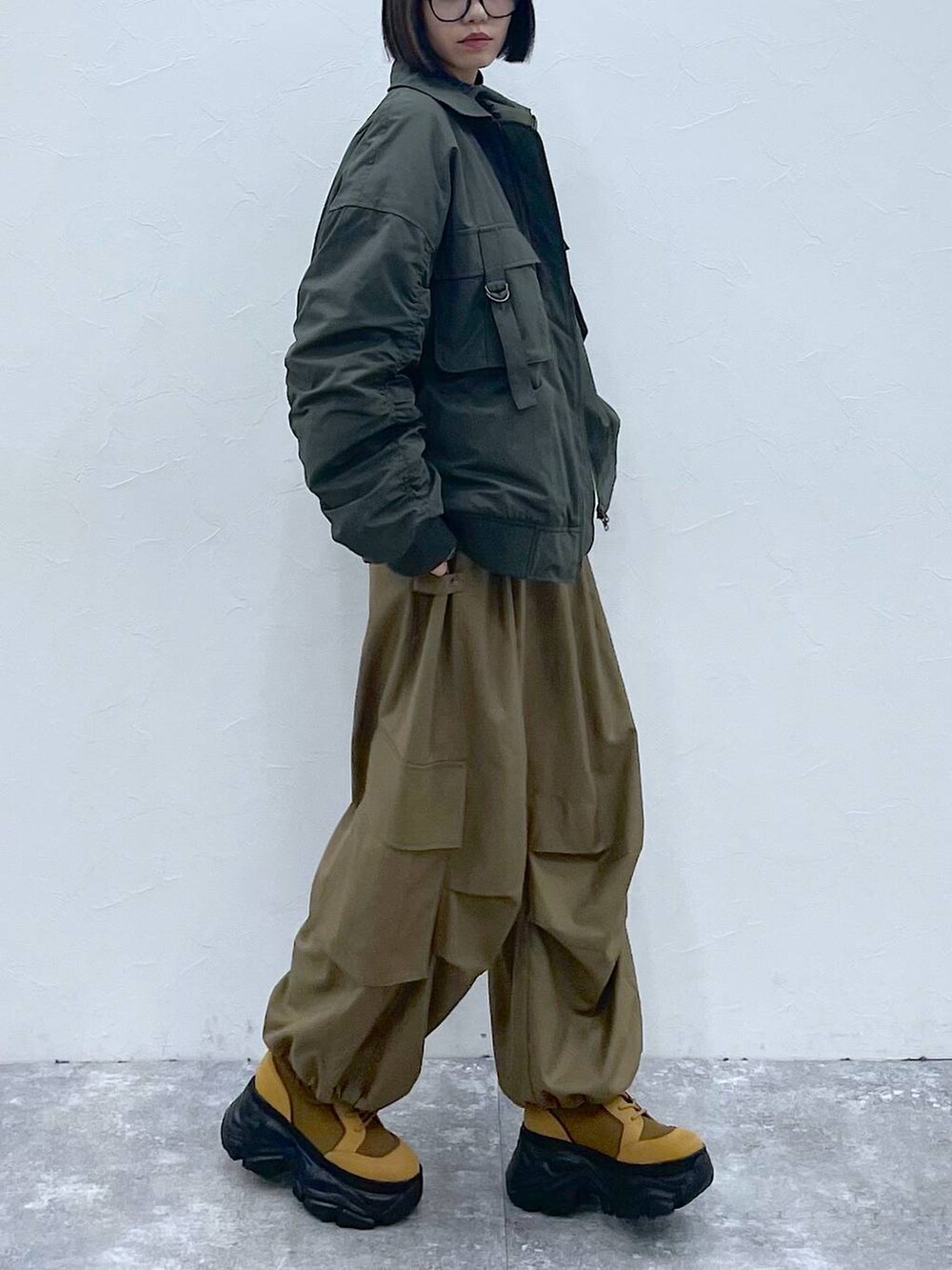 グレー系のネクタイ、ブラウン系のブーツ、グリーン系のブルゾンを着用したレディースの秋コーディネートの8枚目の写真