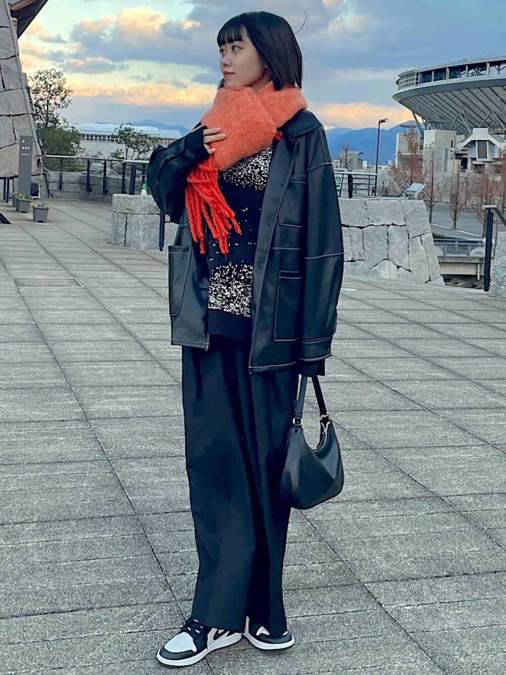 ブラック系のスラックス、ブラック系のニット/セーターを着用したレディースの冬コーディネートの2枚目の写真