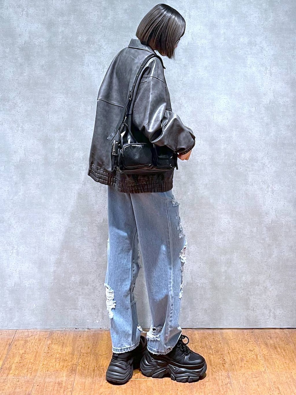 ブラック系のスニーカー、ブルー系のデニムパンツ、グレー系のブルゾンを着用したレディースの秋コーディネートの4枚目の写真