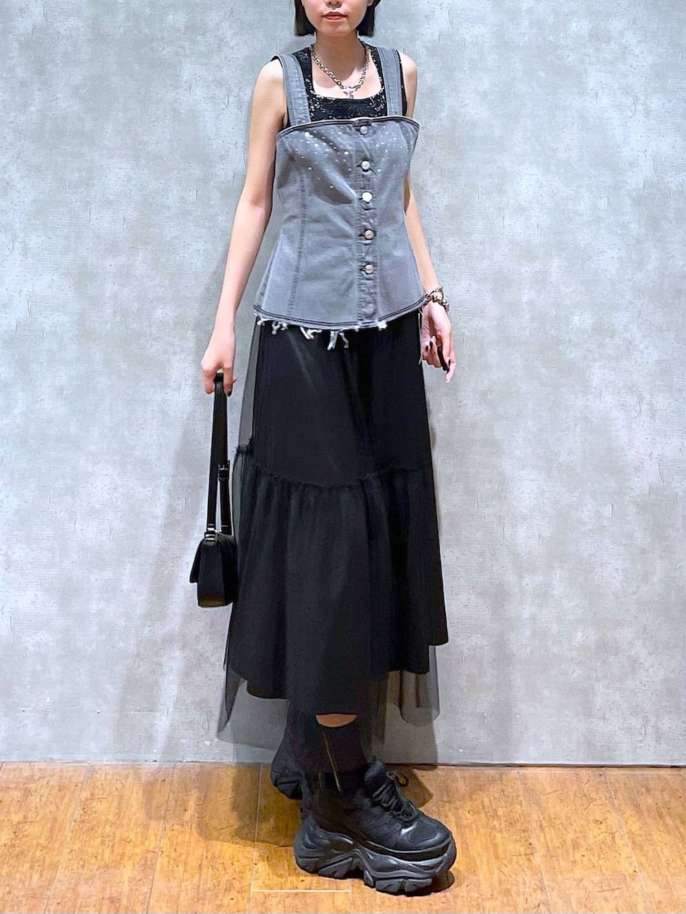 ブラック系のスニーカー、ブラック系のハンドバッグ、ブラック系のスカートを着用したレディースの夏コーディネートの4枚目の写真