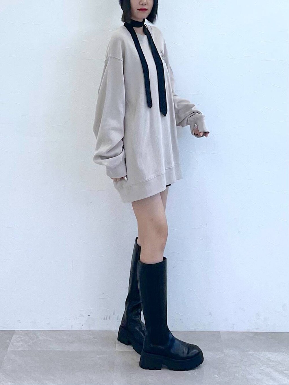 ブラック系のネクタイ、ブラック系のブーツ、ブラック系のその他パンツを着用したレディースの秋コーディネートの4枚目の写真