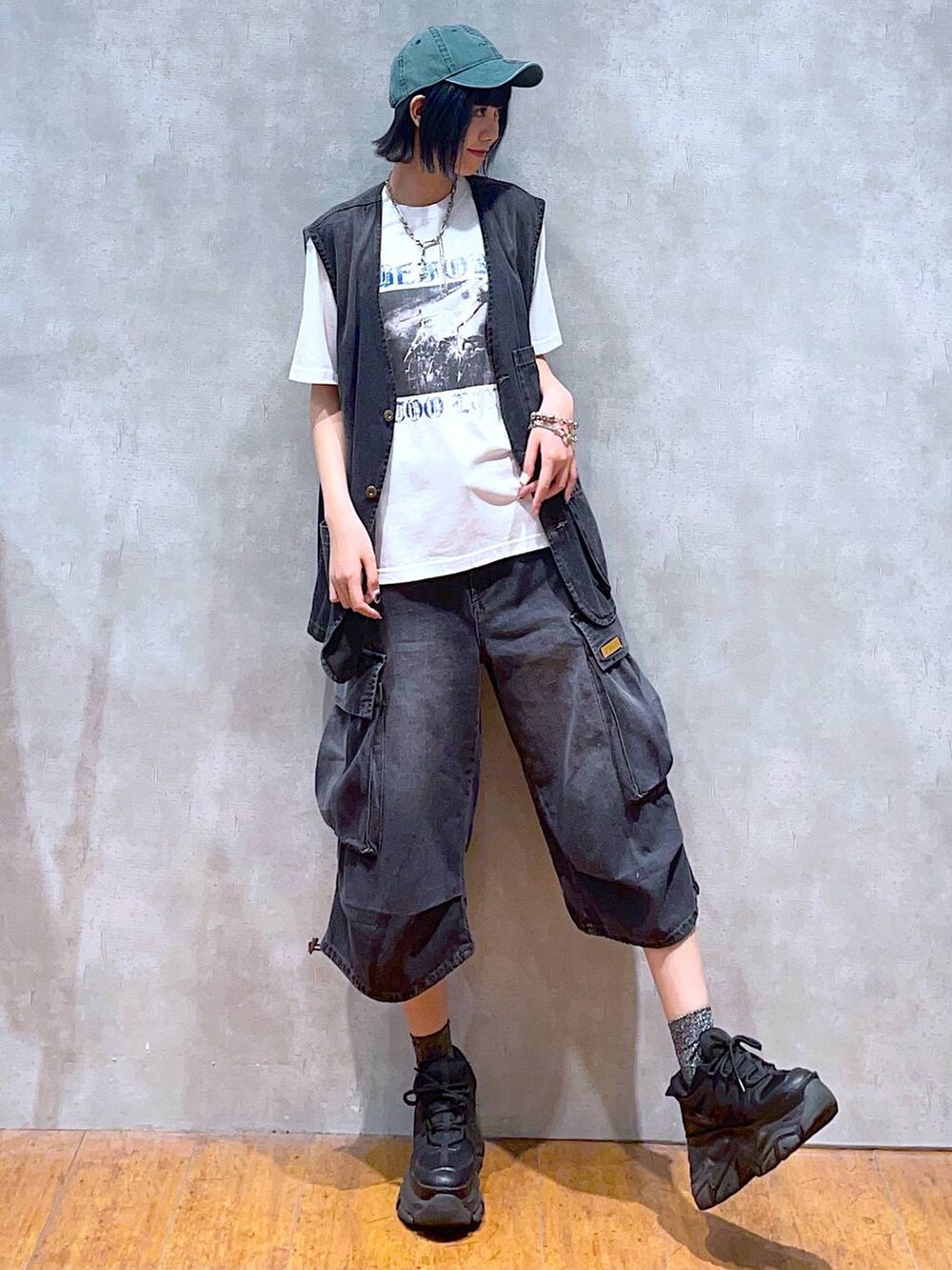 ブラック系のスニーカー、ホワイト系のTシャツ/カットソー、ブラック系のデニムパンツを着用したレディースの夏コーディネートの2枚目の写真