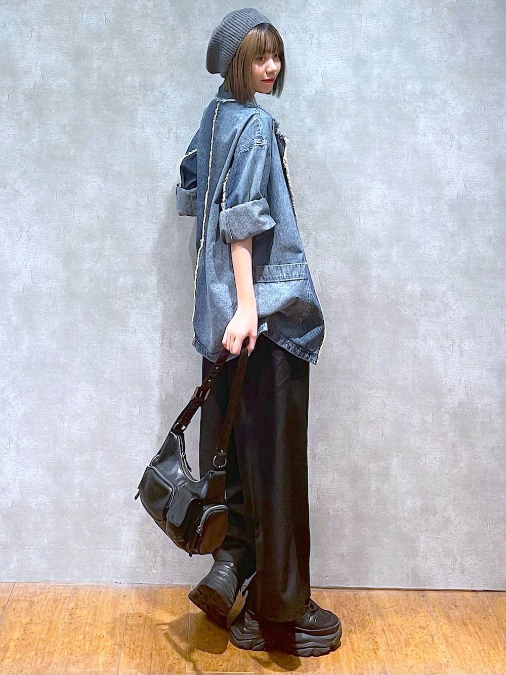 ブラック系のスニーカー、ブルー系のテーラードジャケット、ブラック系のキャミソールを着用したレディースの秋コーディネートの6枚目の写真