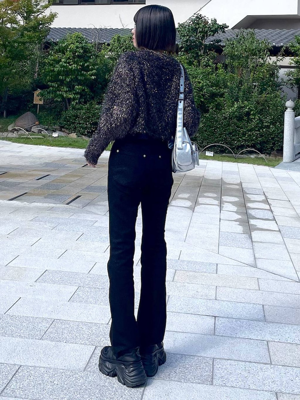 ブラック系のスニーカー、シルバー系のショルダーバッグ、ブラック系のニット/セーターを着用したレディースの秋コーディネートの4枚目の写真