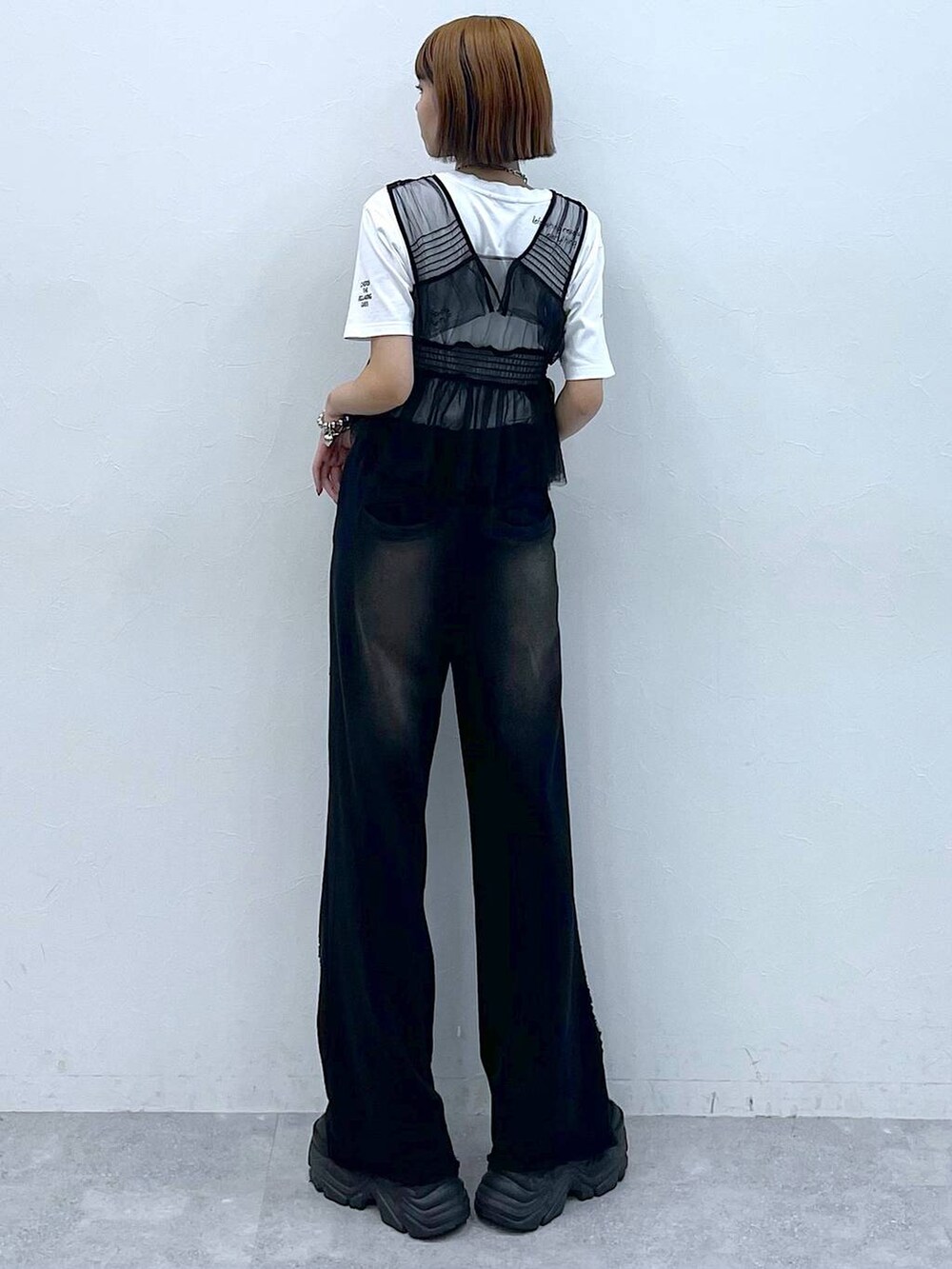 ブラック系のスニーカー、ブラック系のベスト、ホワイト系のTシャツ/カットソーを着用したレディースの夏コーディネートの6枚目の写真